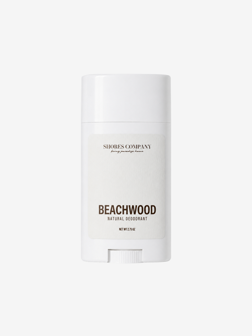 A white deodorant stick container from Shores Company, labeled 'Beachwood Natural Deodorant', centered on a light gray background.