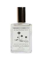 Perfume bottle labeled 'Shores Company' with palm tree design on a white background