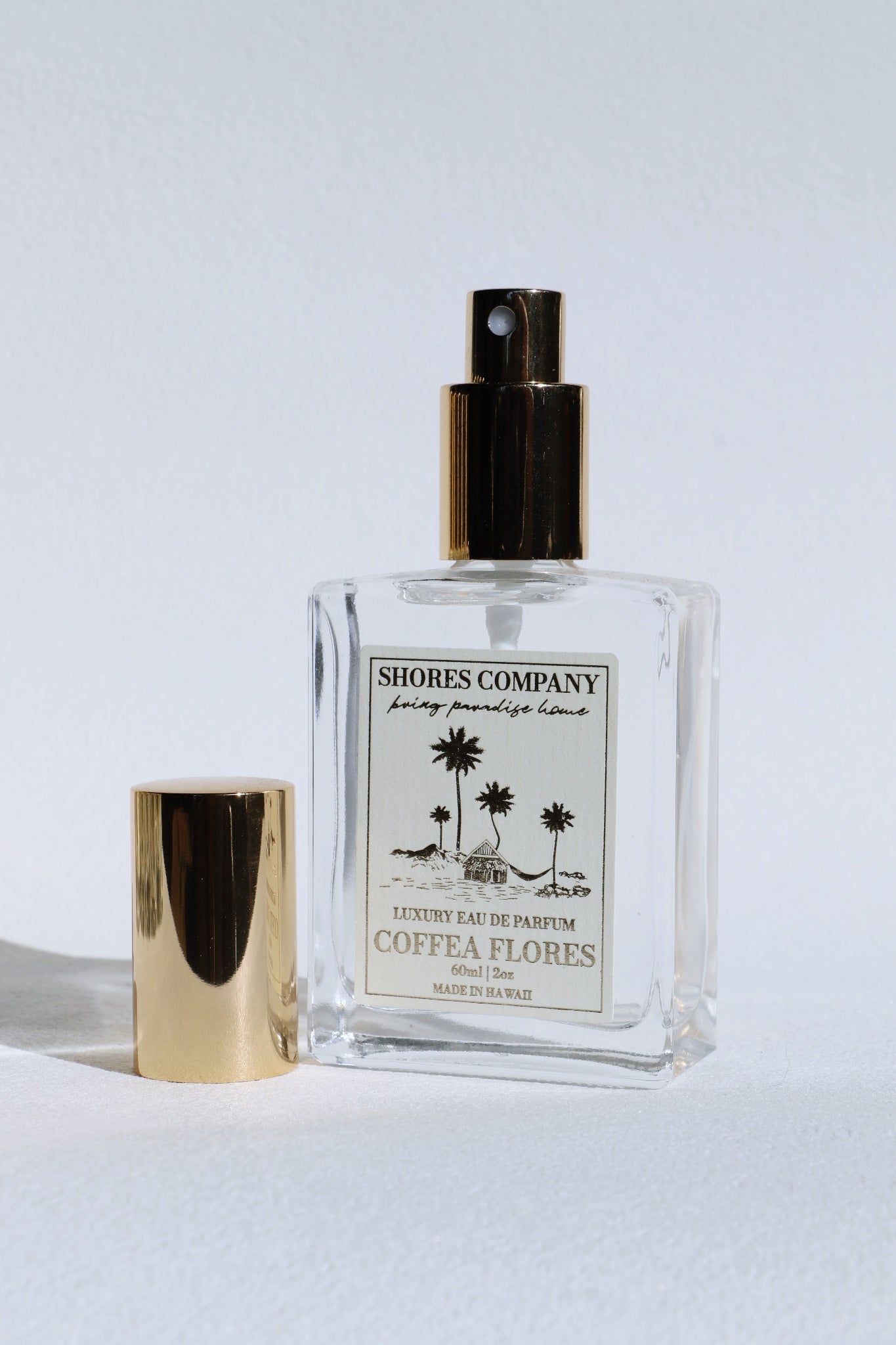 Island Perfume bottle with gold cap and label on a light gray background