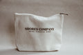 Beige pouch with 'Shores Company' branding on a beige background