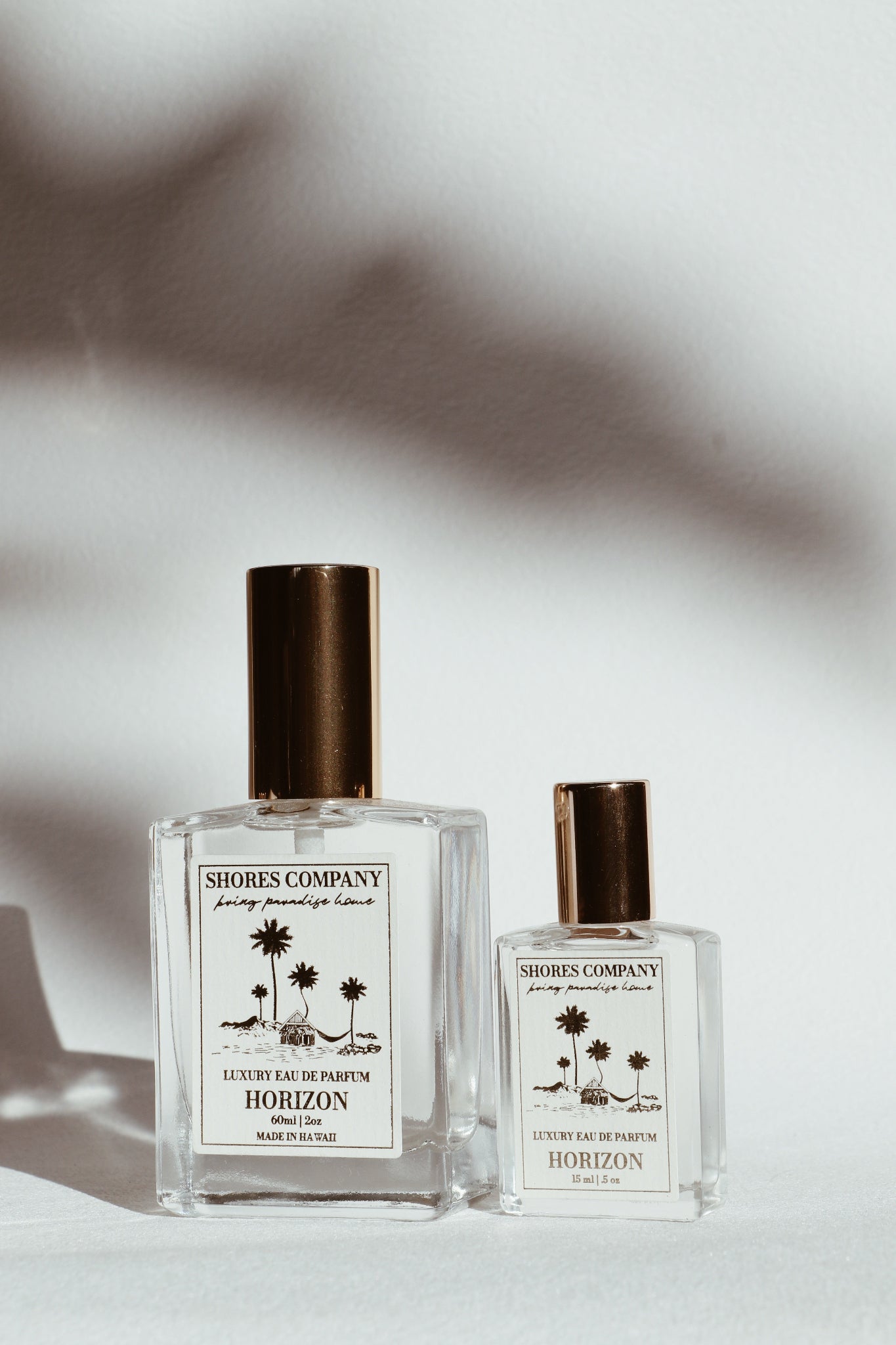 Two perfume bottles from Shores Company on a light background