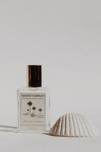 Shores Company perfume bottle with a shell on a light background