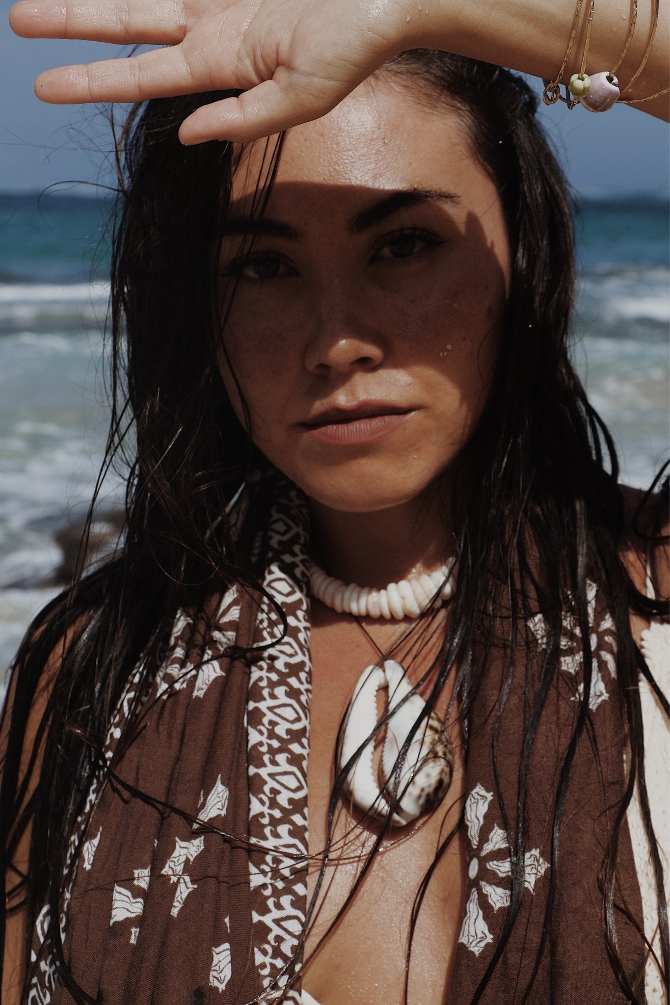 Woman on a beach with ocean in the background wearing isle sarong
