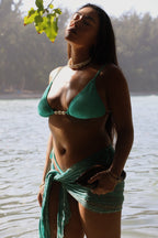 Model wearing turquoise rayon pareo wrap at the beach