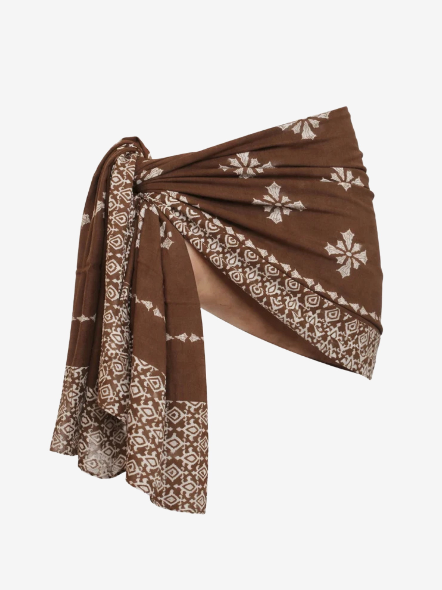A brown wrap or sarong with cream-colored block-print patterns and shell motifs, tied in a knot on a plain white background.