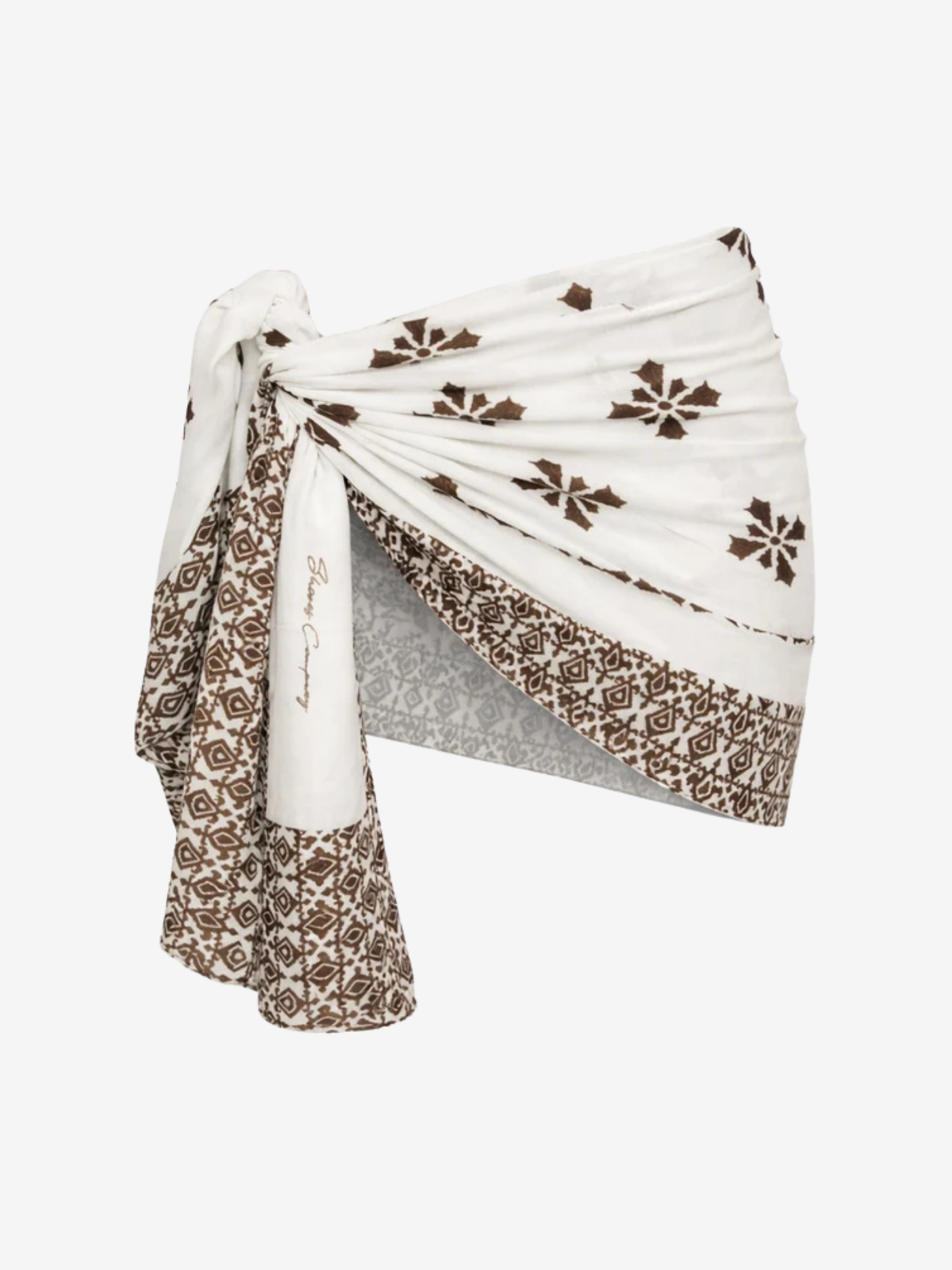 A white wrap-style scarf or sarong with brown floral and geometric patterns, tied in a knot to display its drape and border details, set against a plain light gray background.
