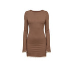 Brown dress with long sleeves and cowrie details on a white background