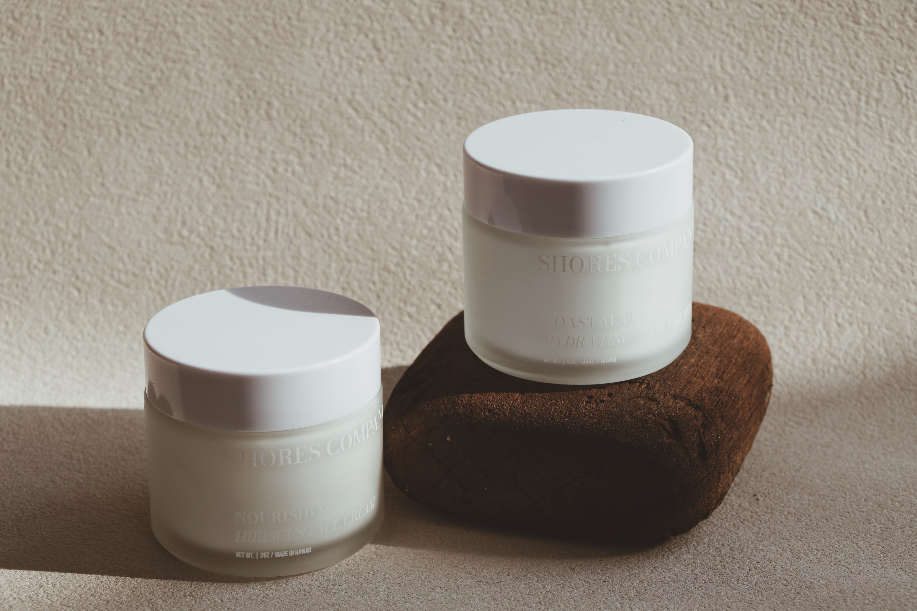 Two Shores Co Skin Care containers with lids on a textured surface