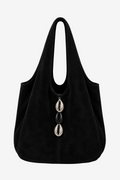 A black suede slouchy shoulder bag with a triple Silver/Black cowries photographed against a neutral light gray background.