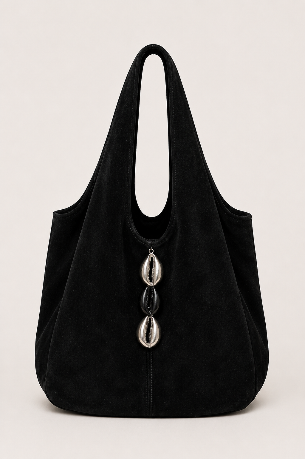 A black suede slouchy shoulder bag with a triple Silver/Black cowries photographed against a neutral light gray background.