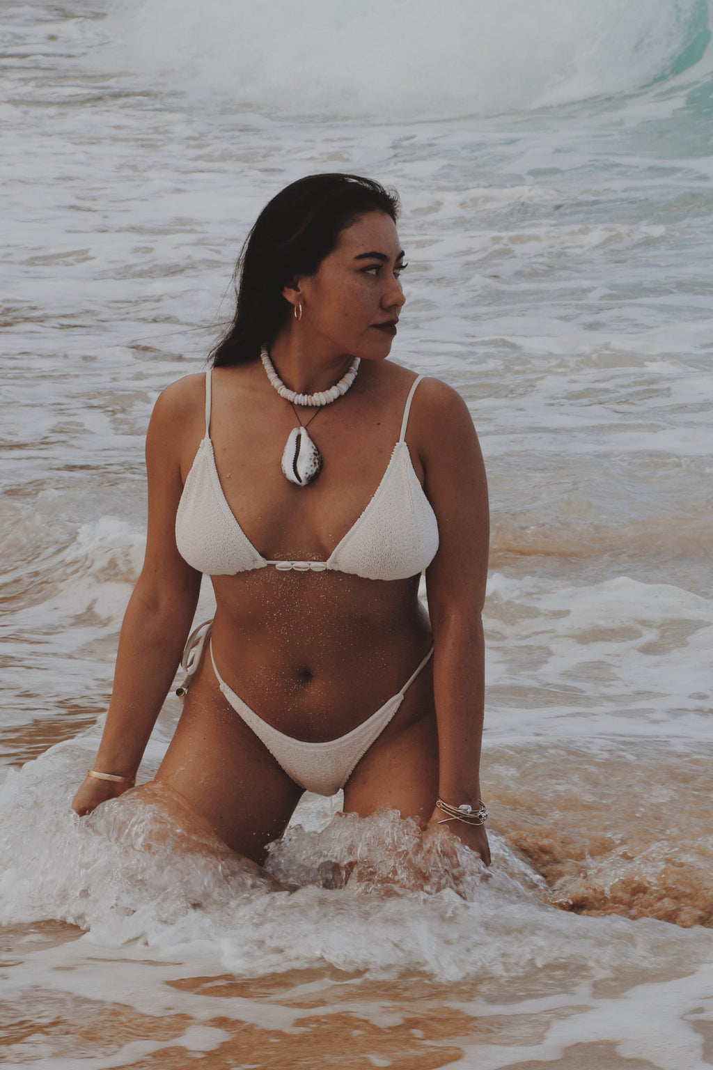 Woman in a Vai white bikini standing in ocean water