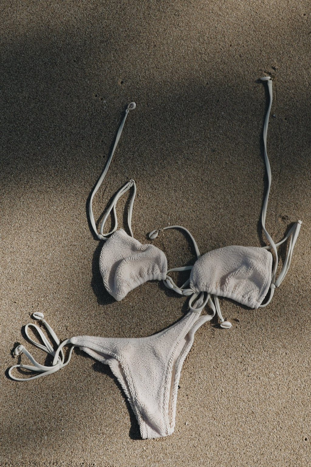 Vai bikini set on a sandy surface