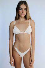 Woman wearing Vai white bikini against a light gray background