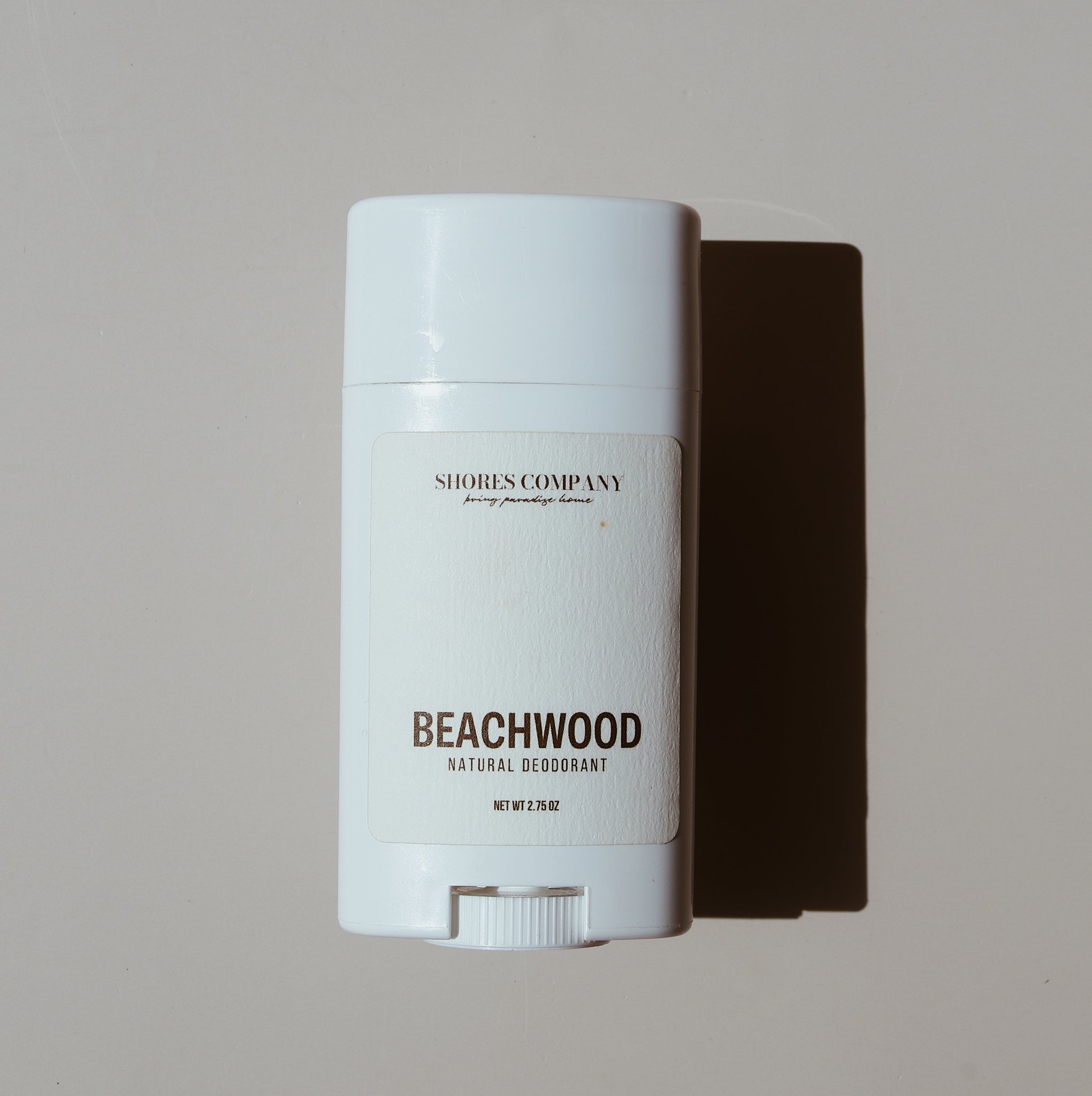 Shores Company Beachwood Natural Deodorant in a minimalist white tube with elegant branding on a neutral background.