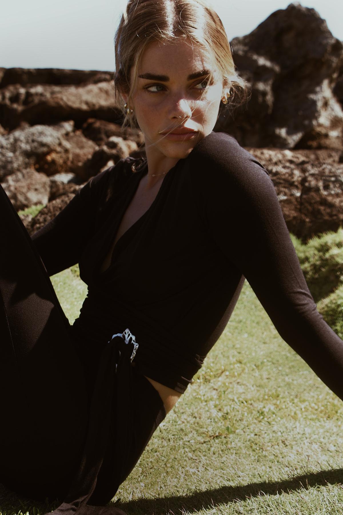 Brisa Wrap Crop Top in Abyss captured outdoors with sunlit backdrop

