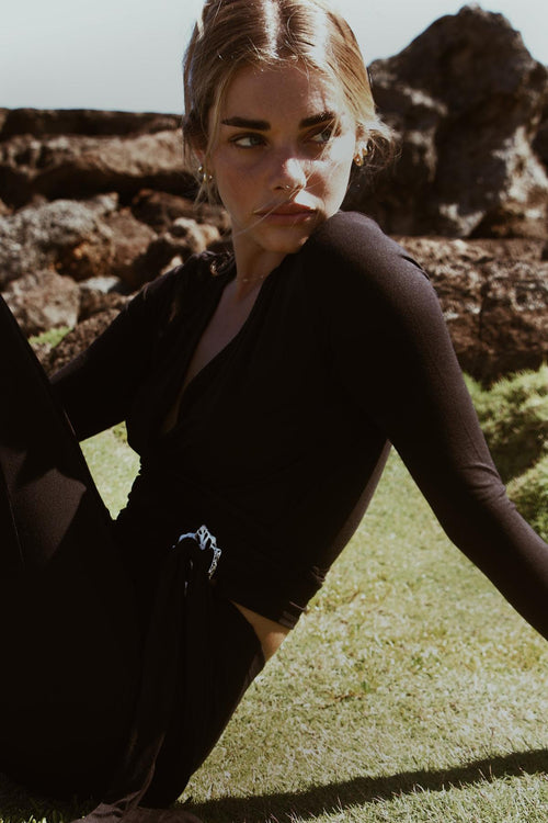 Brisa Wrap Crop Top in Abyss captured outdoors with sunlit backdrop

