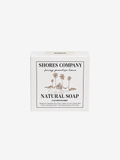 A white rectangular box of Shores Company Natural Soap with a tropical palm tree illustration and black text, centered on a light gray background.