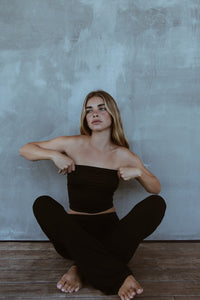 Model seated in the Indah Lounge Pant, styled with a black bandeau top. Relaxed fit with soft bamboo drape.