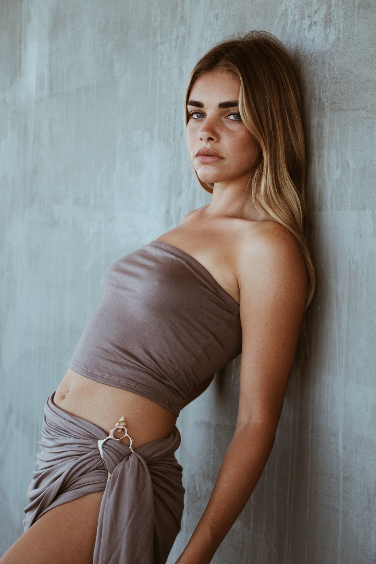 Side angle of Kirra Set in Coco Husk showing elegant sarong wrap and shell ring accent.