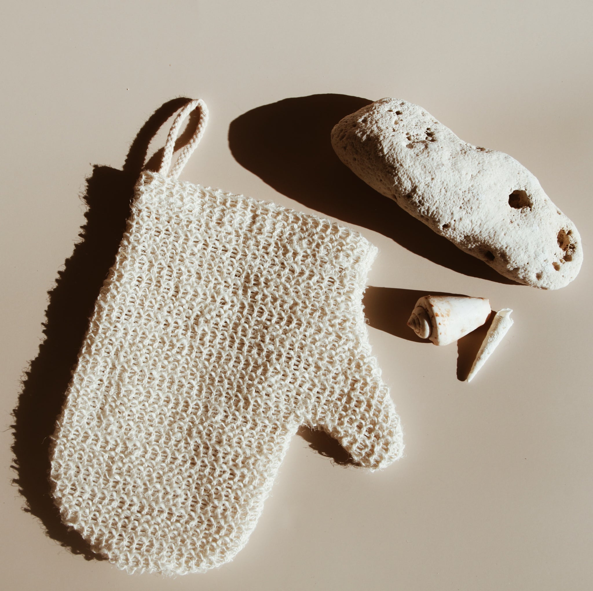 Flat Lay of Handwoven Natural Ramie Exfoliating Mitt with Hanging Loop – A minimalist exfoliating mitt, crafted for sustainable self-care, photographed in soft Hawaiian sunlight to capture its luxurious texture.