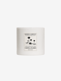 A white ceramic jar candle with a black printed label reading 'Shores Company' and 'Coffea Flores' with a palm tree illustration, centered on a light gray background.