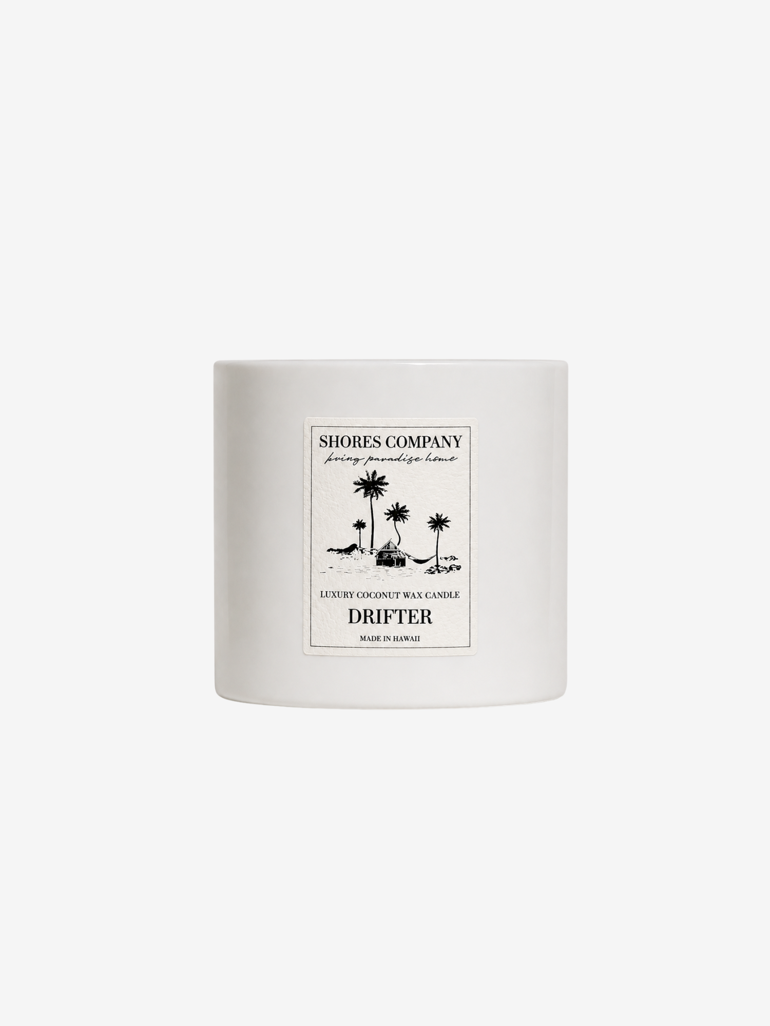 A white ceramic candle jar with a minimalist black-and-white tropical illustration label on the front, reading 'Shores Company' and 'Drifter'.