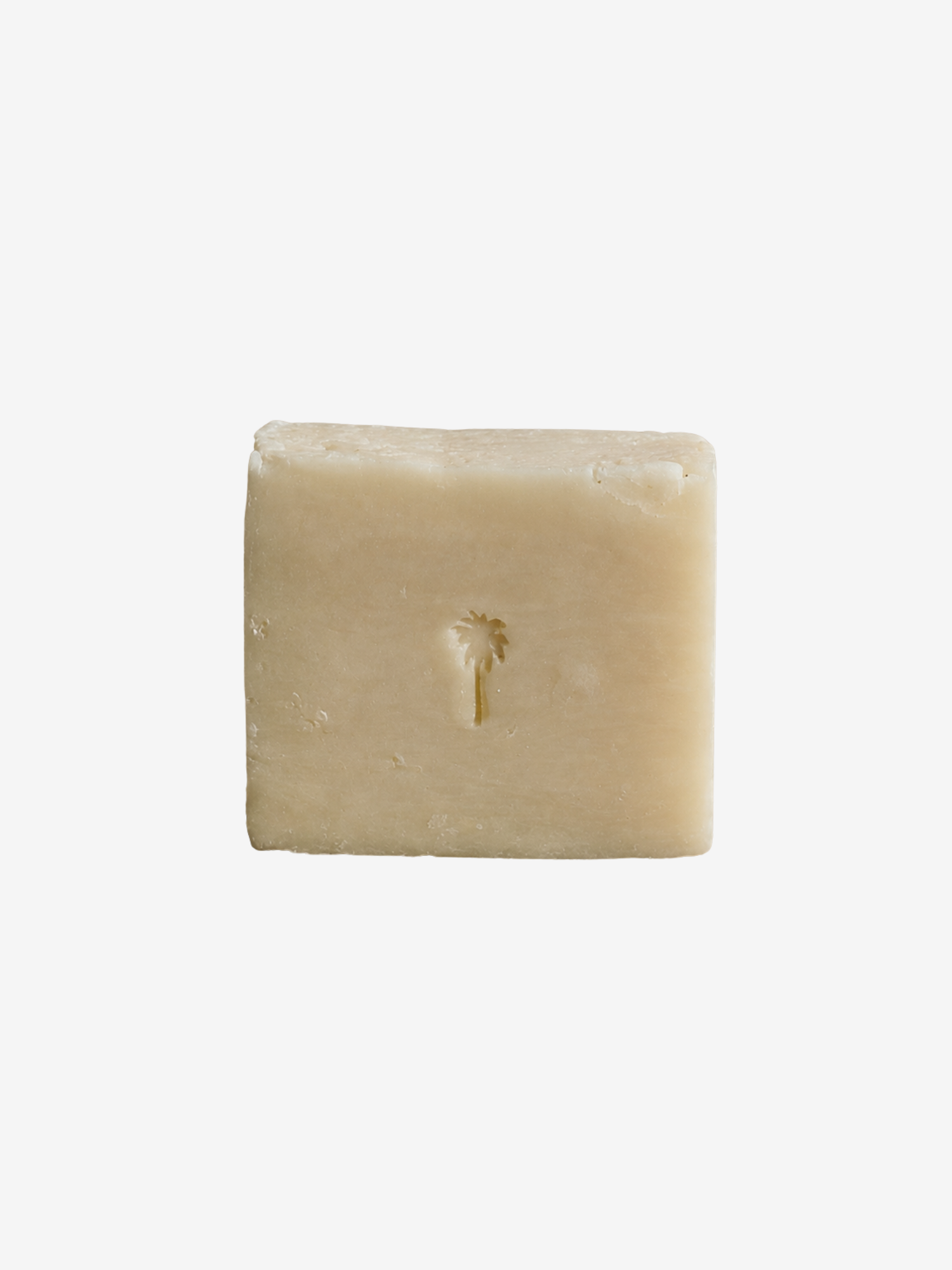 A single rectangular bar of pale cream-colored soap with a small palm tree imprint in the center, shown on a plain white background.