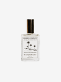 Shores Company Windswept Monochromatic perfume oil in a clear glass bottle with a black cap and a white label featuring black text and palm tree illustrations, set against a light gray background.