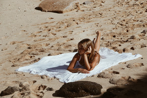 Embracing the island lifestyle on a warm beach day with the Mo'orea beach blanket, crafted for comfort, style, and a touch of coastal elegance. The ultimate beach essential from Shores Company.